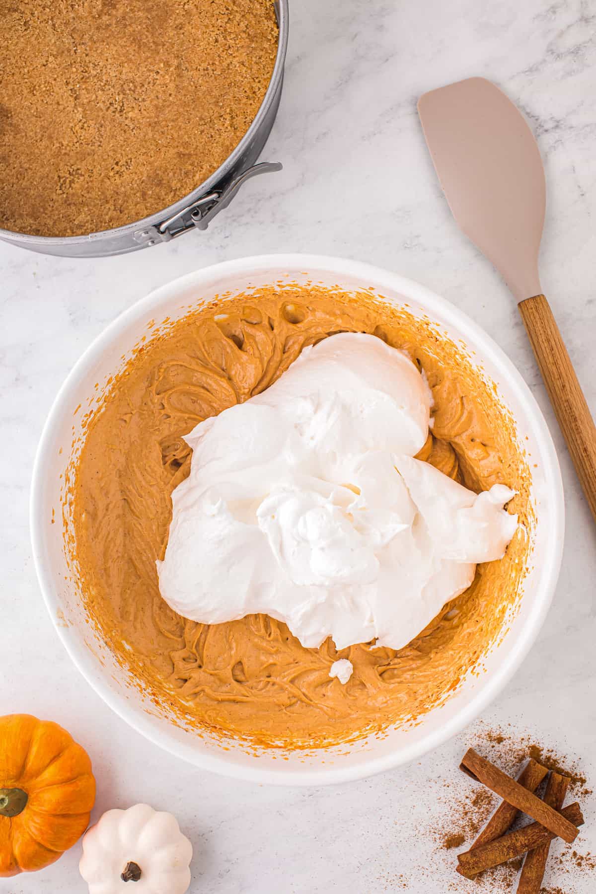 Whipped topping and pumpkin cheesecake filling in bowl