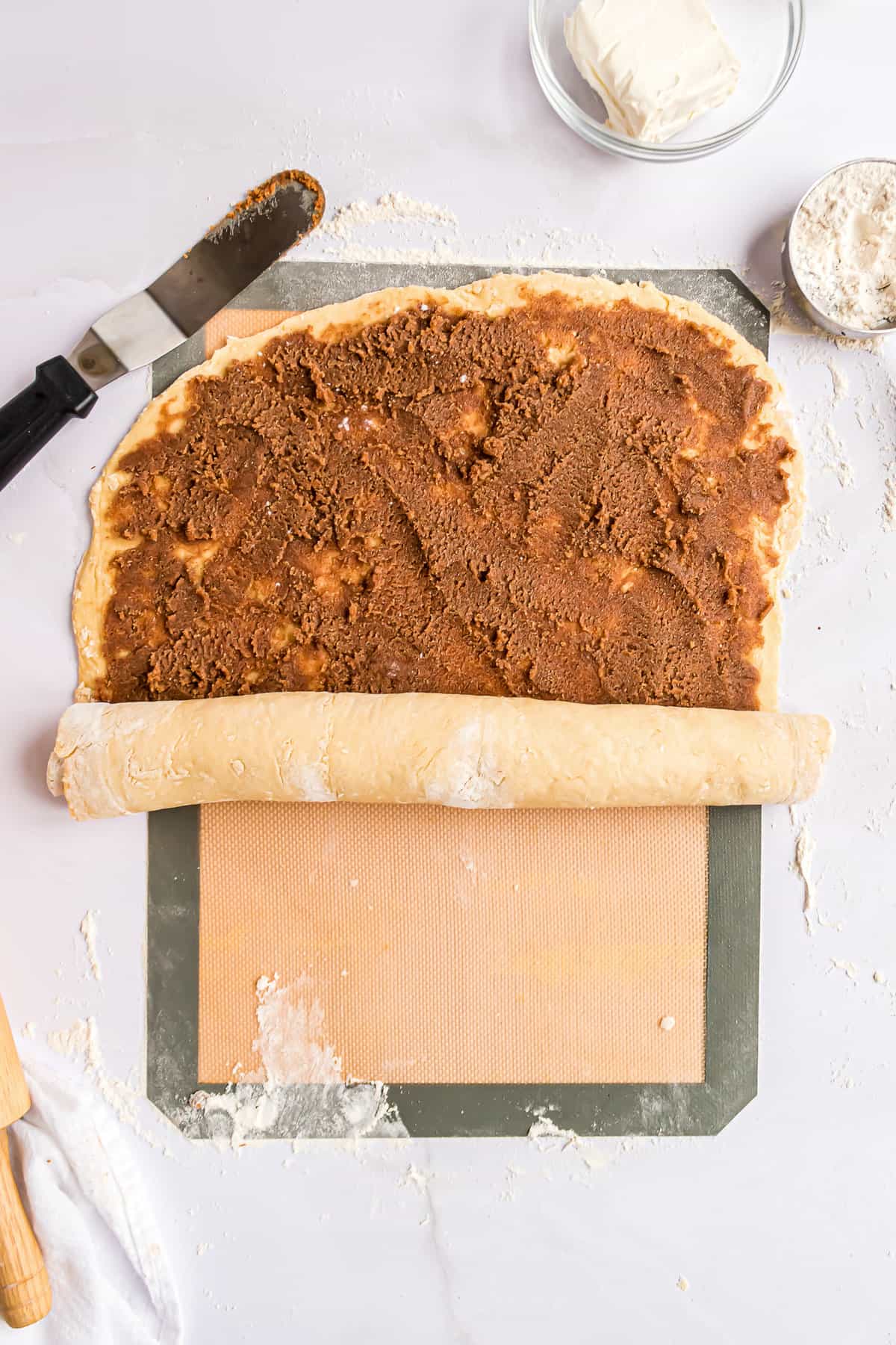 Rolling up cinnamon roll dough