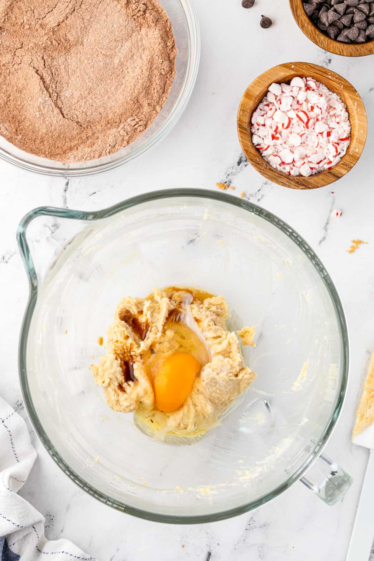 Egg in bowl with creamed cookie ingredients