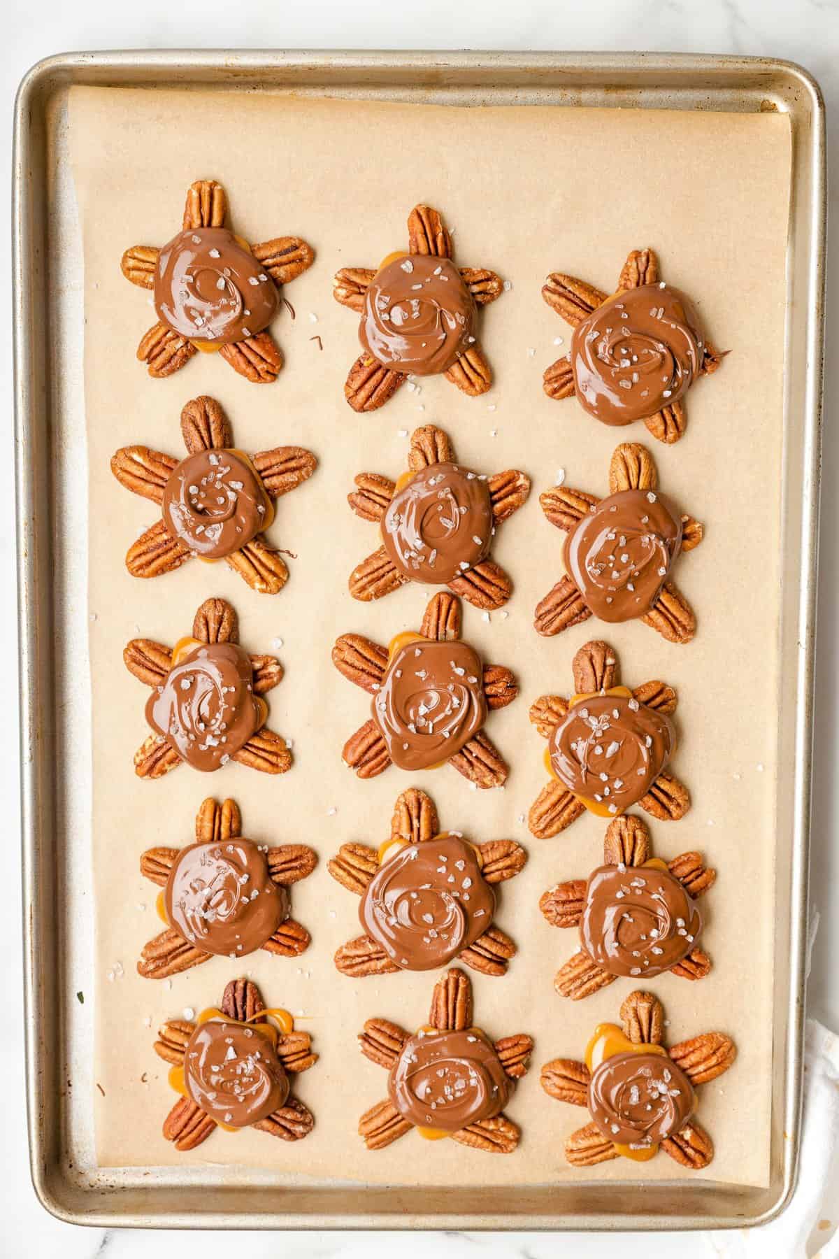 Overhead image of chocolate turtles on baking sheet