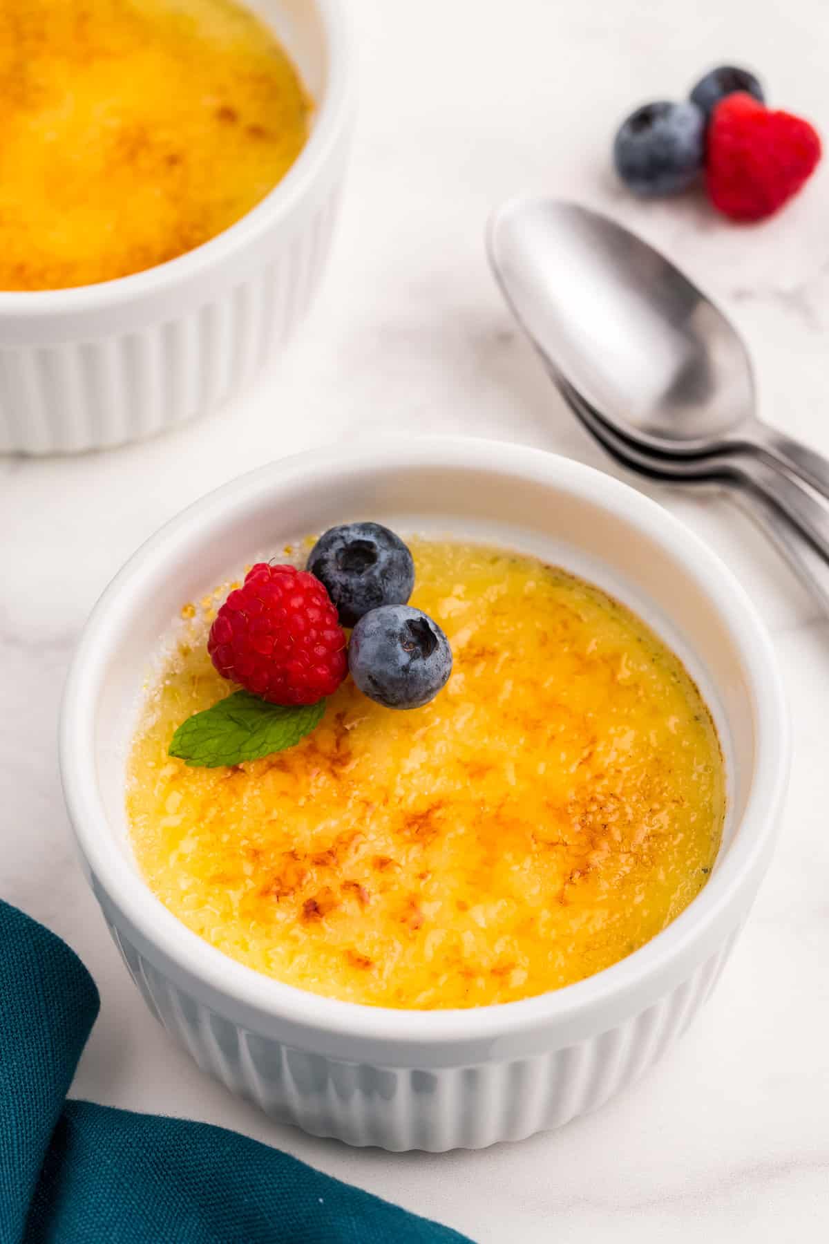 White ramekin with creme brulee and fruit