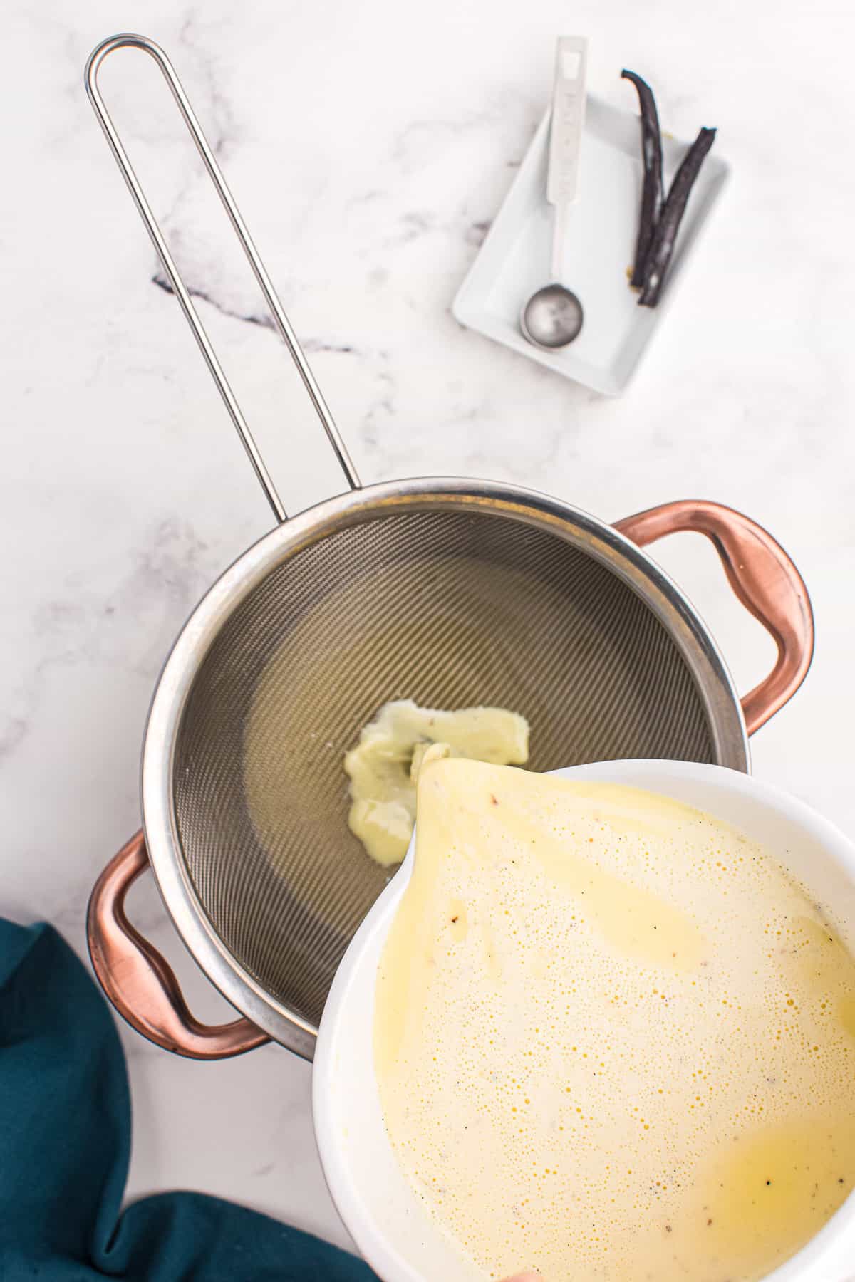 Pouring cream brulee through mesh sieve