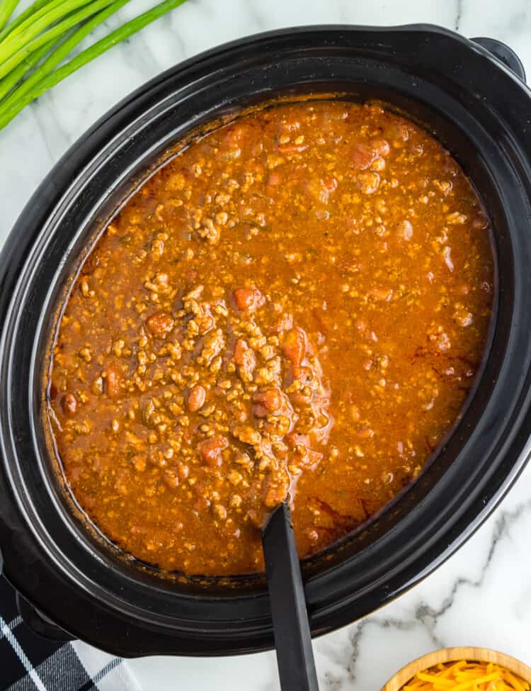 Ladle lifting chili out of crock pot