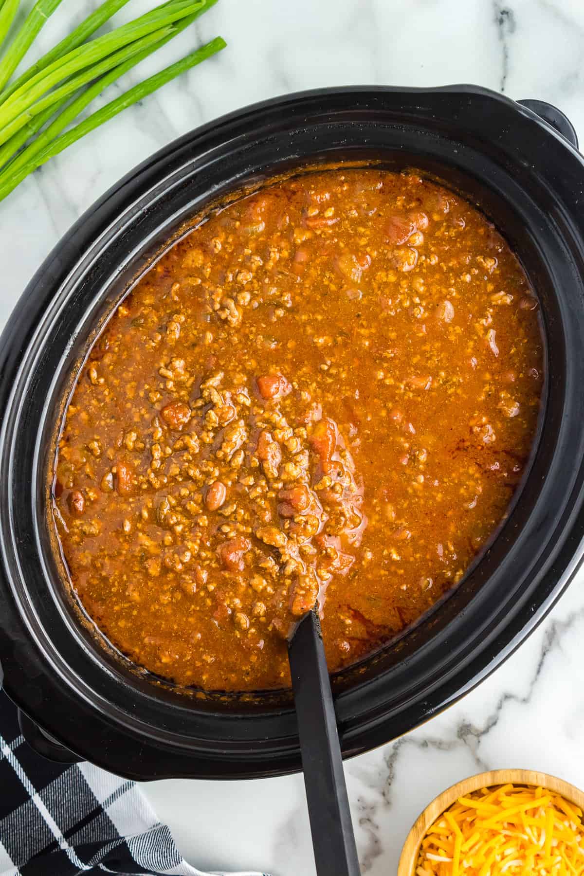 Ladle lifting chili out of crock pot