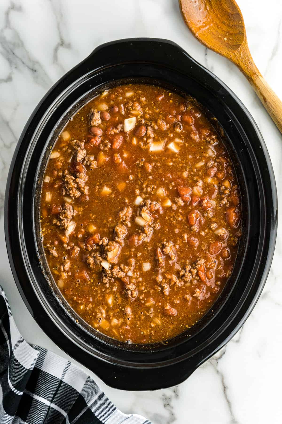 Black crock pot with chili before cooking