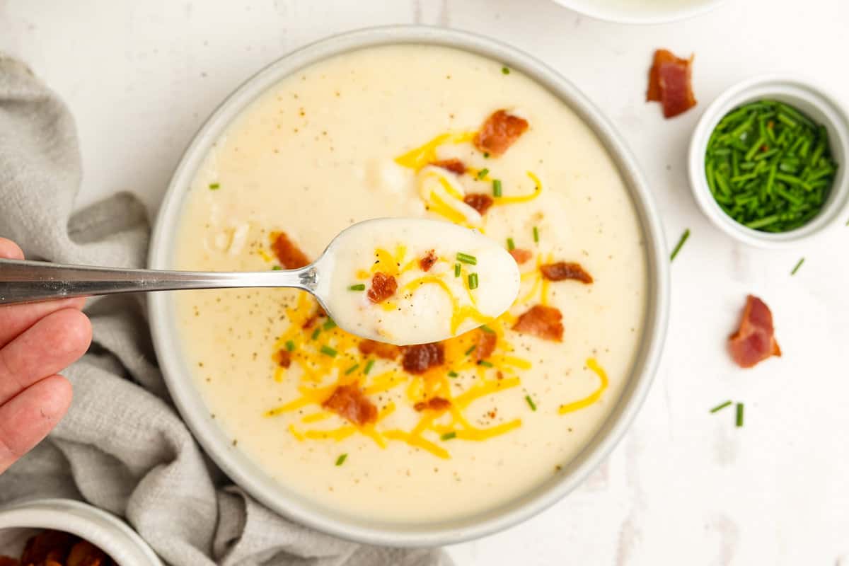 Spoon with a bite of mashed potato soup