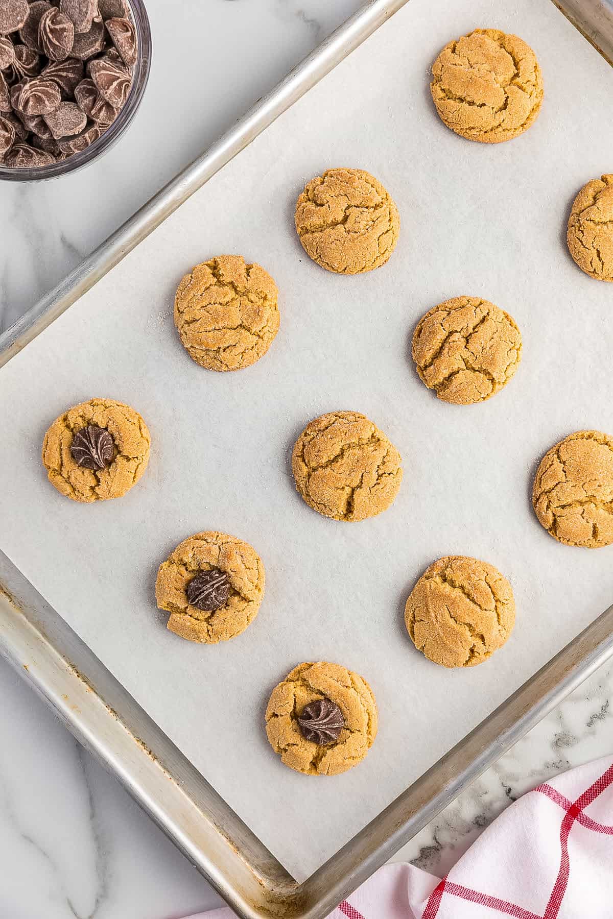 Overhead image of a sheet pan with baked peanut butter blossoms