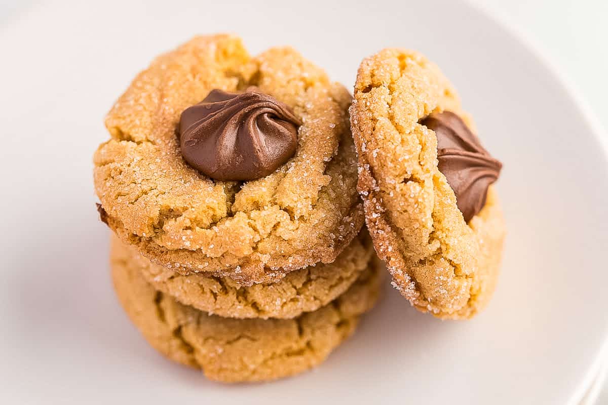 Peanut Butter Blossom cookies stacked on white plate