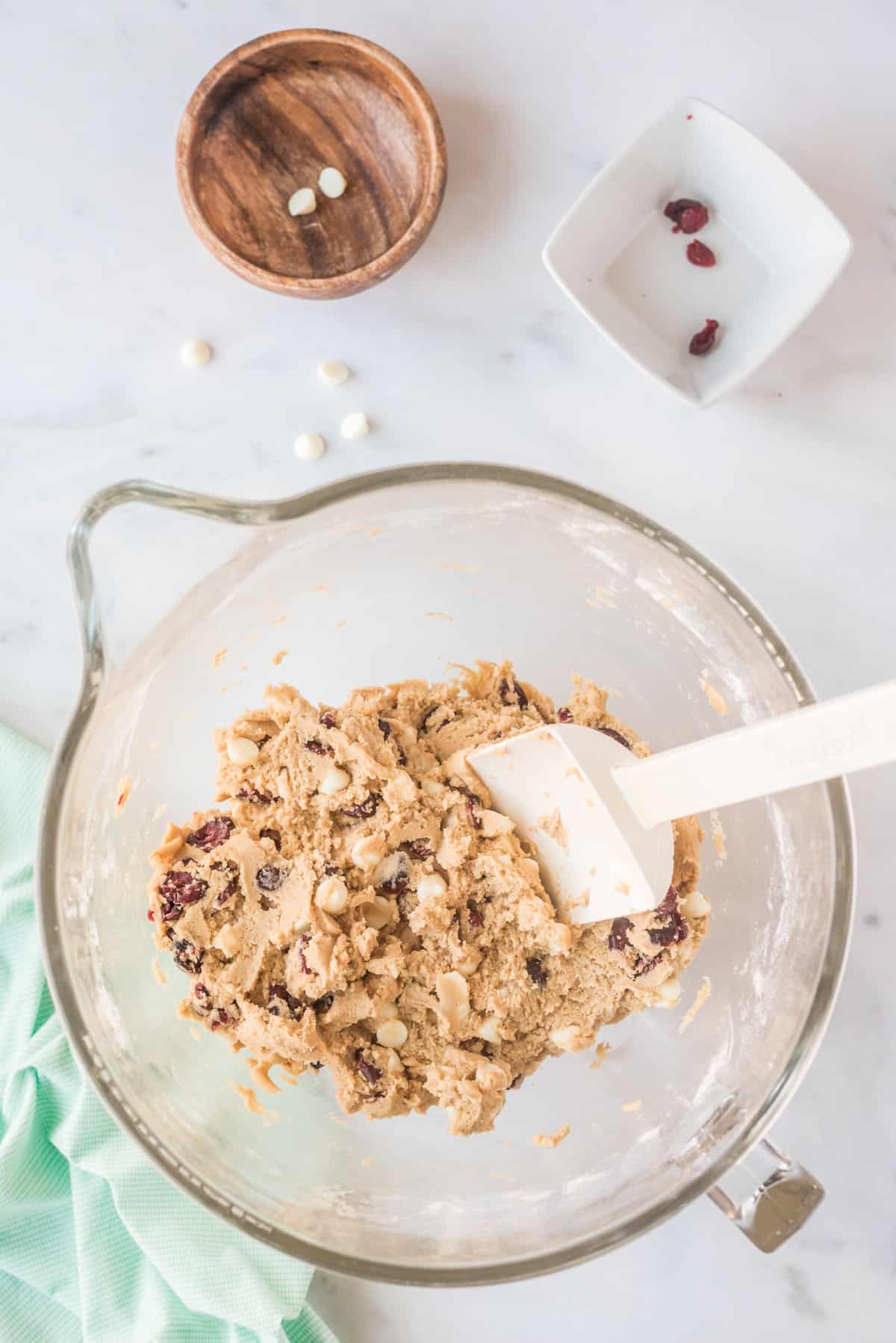 Cookie dough with white chips and dried cranberries on top mixed in