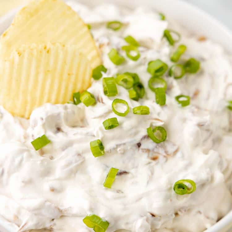 Chip in a bowl of Caramelized Onion Dip