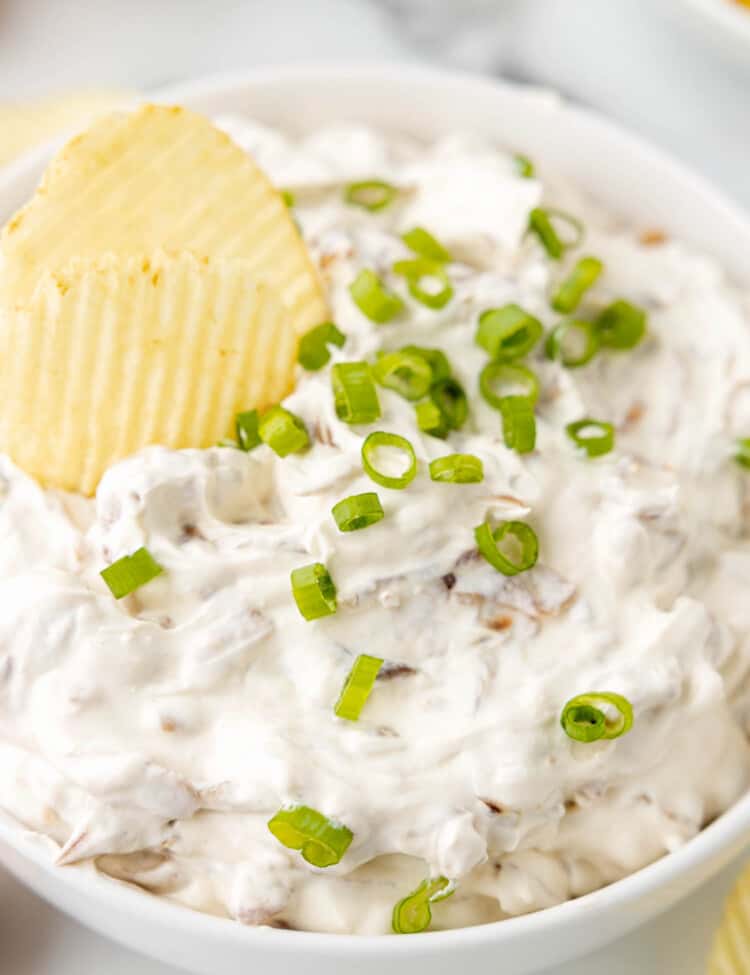 Chip in a bowl of Caramelized Onion Dip