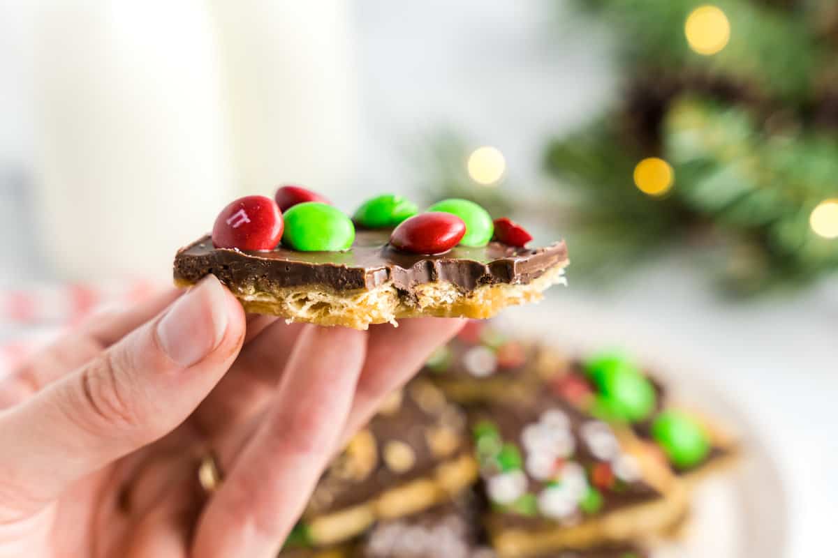 Hand holding a piece of Christmas crack with M&Ms