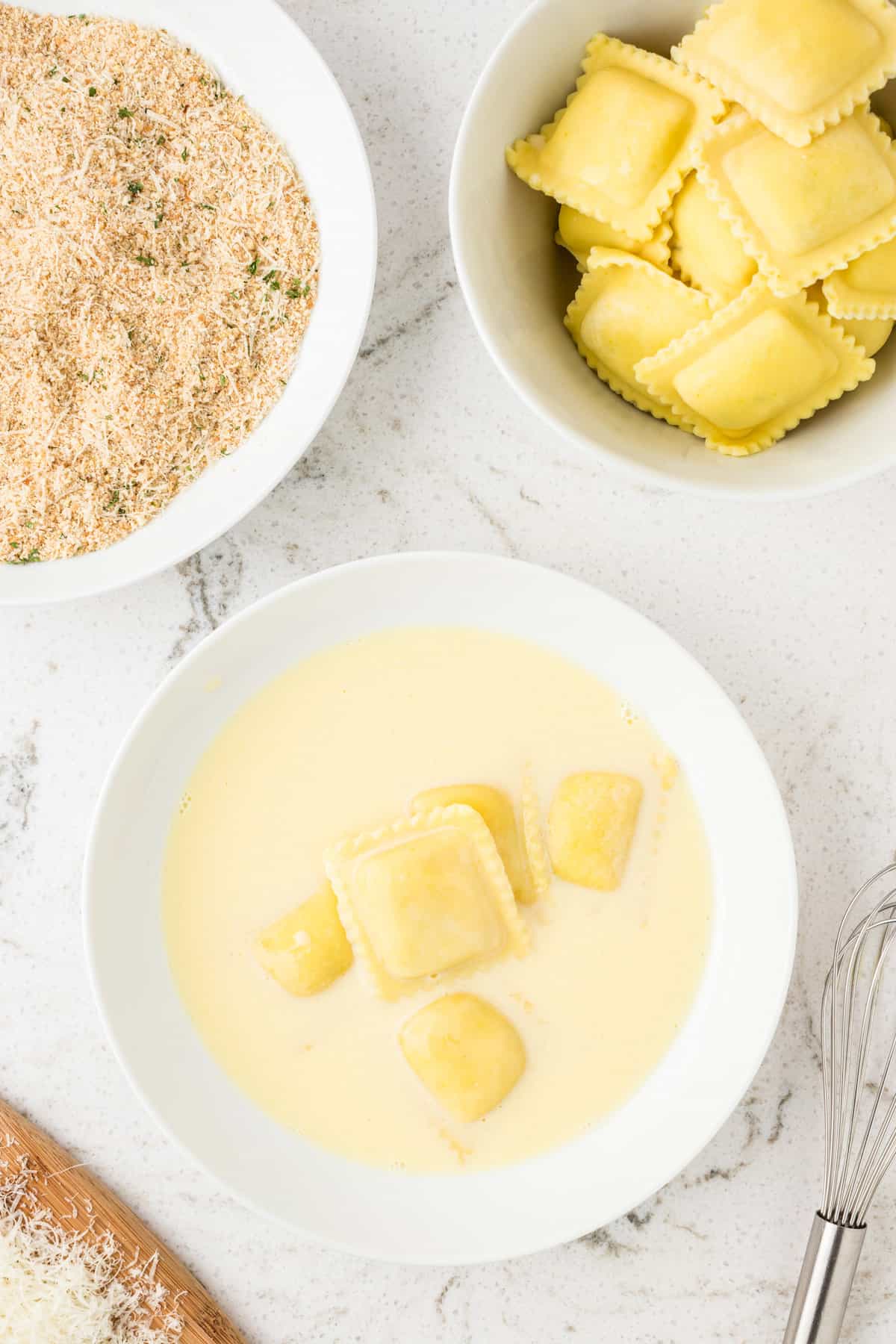 Overhead of ravioli in whisked egg mixture