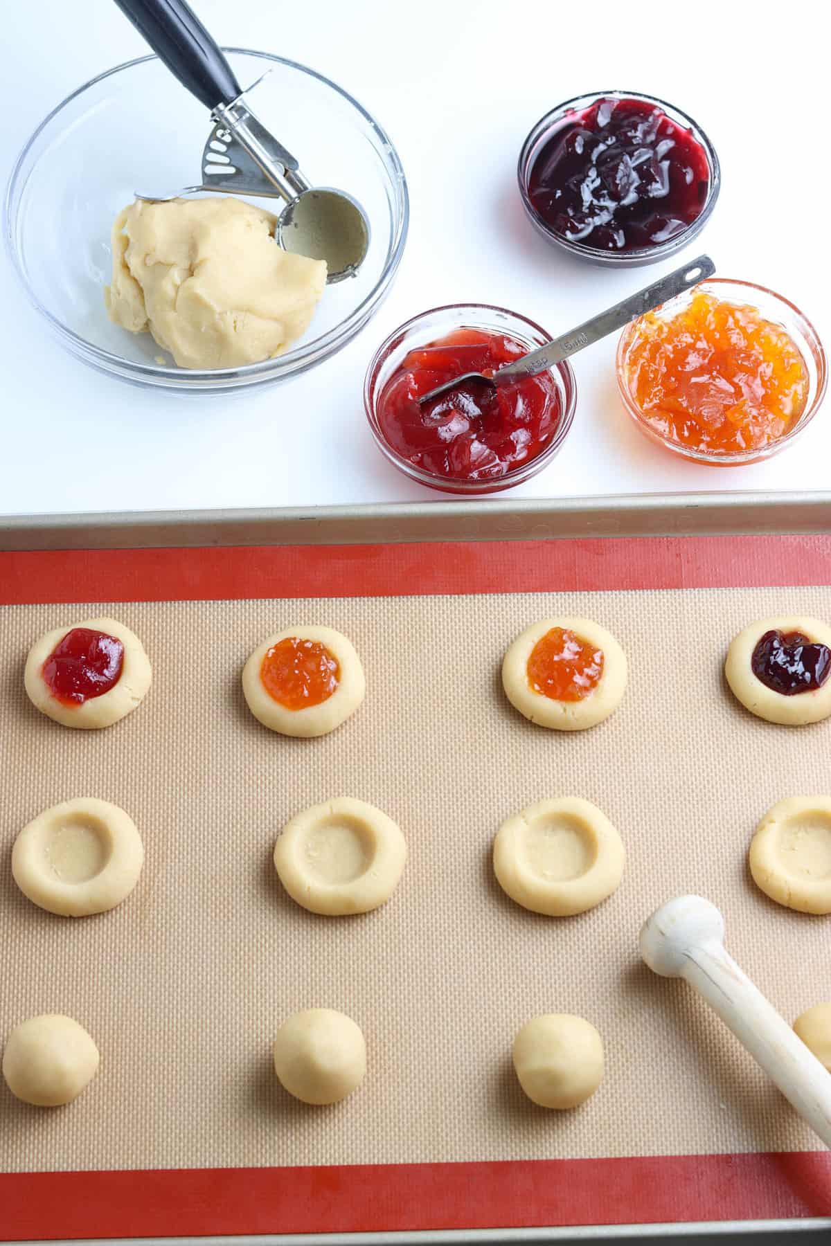 Thumbprint Cookies on Lined Baking Sheet with Seedless Jam