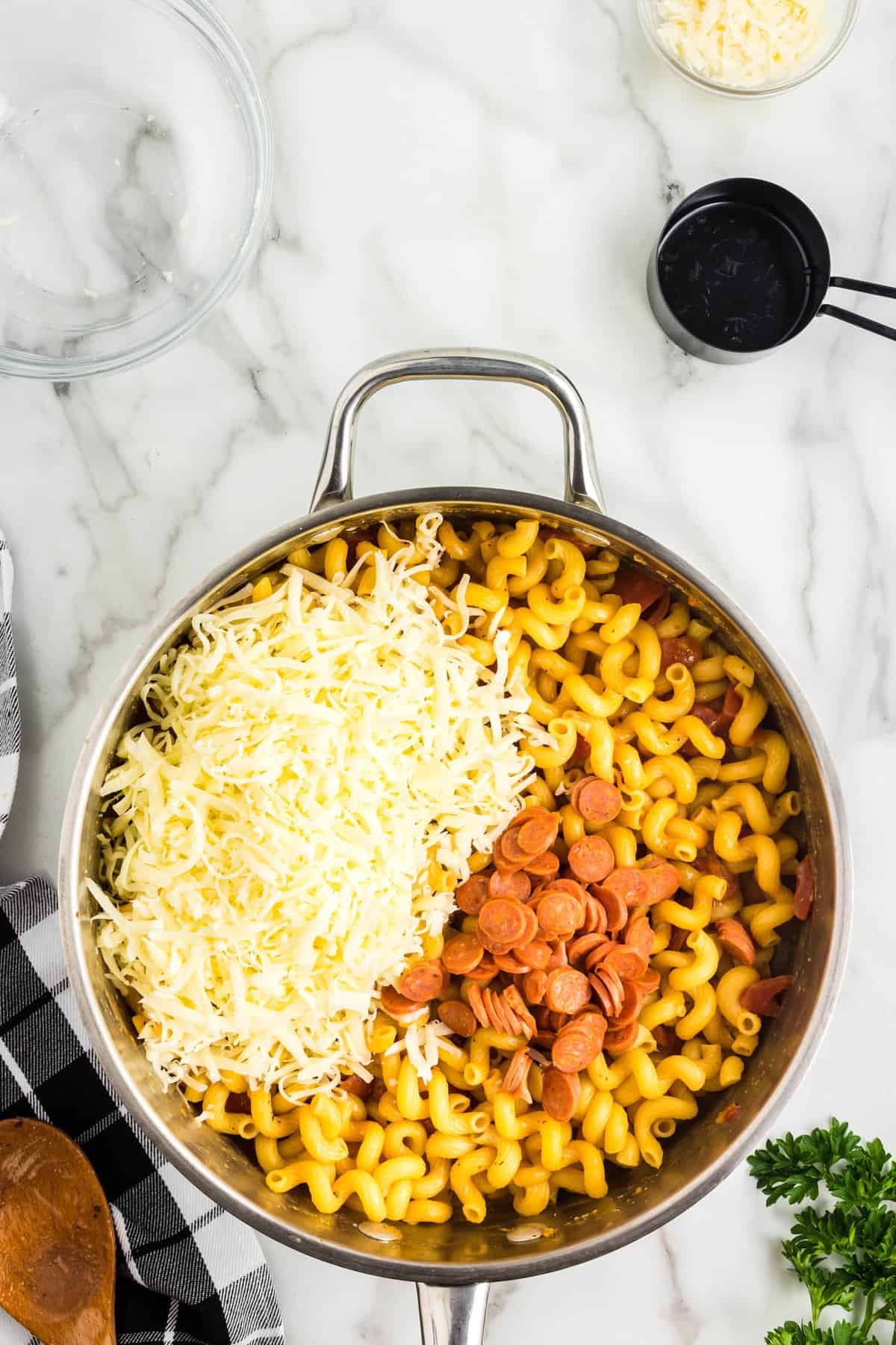 Stirring in Shredded Mozzarella Cheese and Pepperonis into One Pot Pasta Recipe