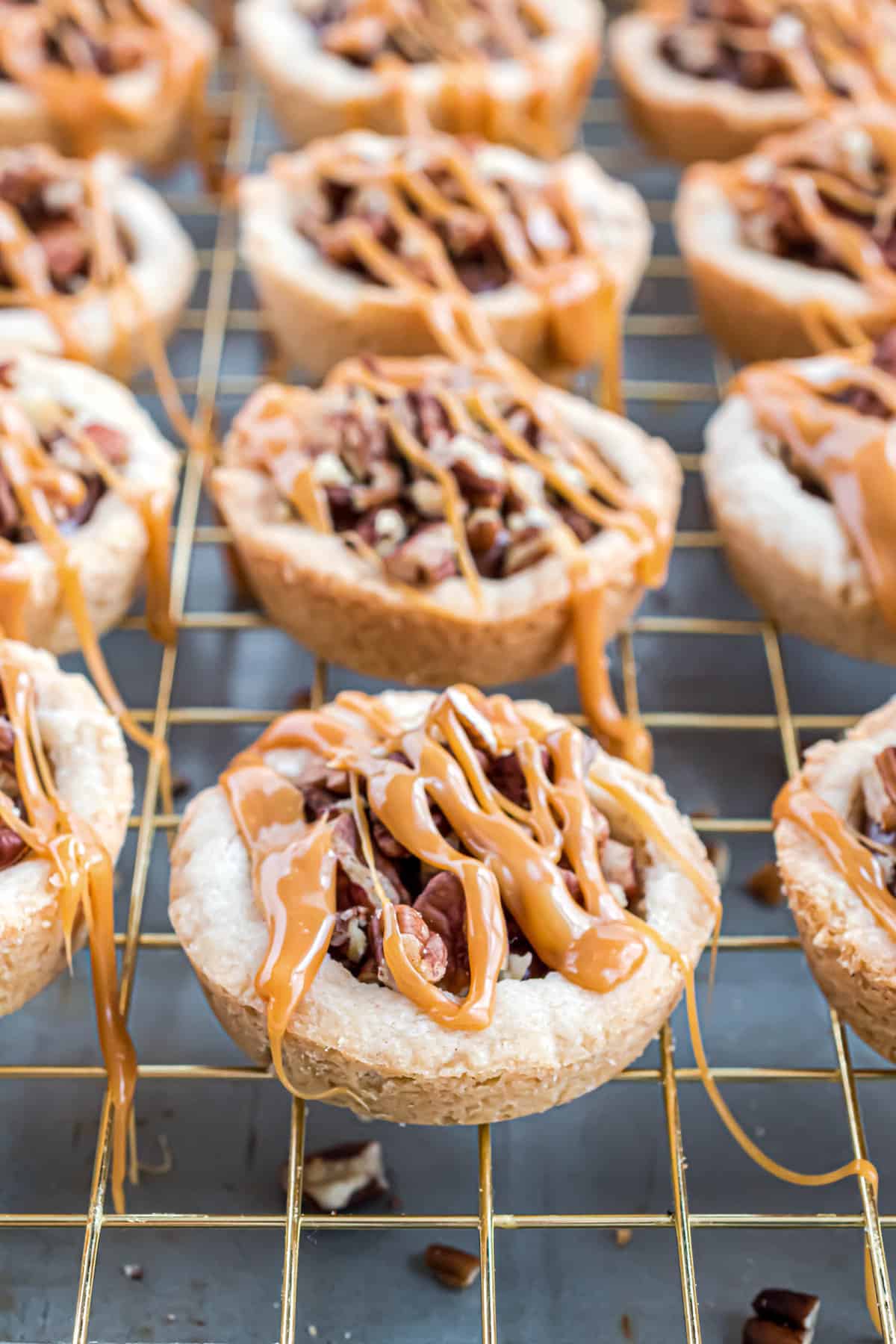 Cookie cups drizzled with caramel on baking rack