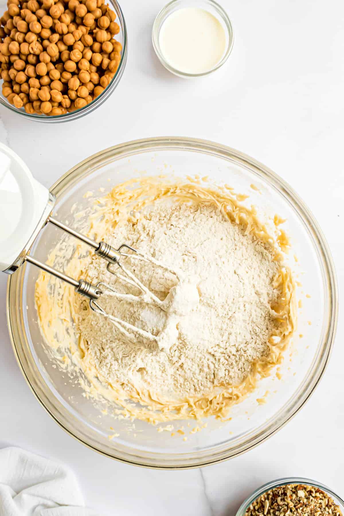 Adding flour to cookie dough in bowl
