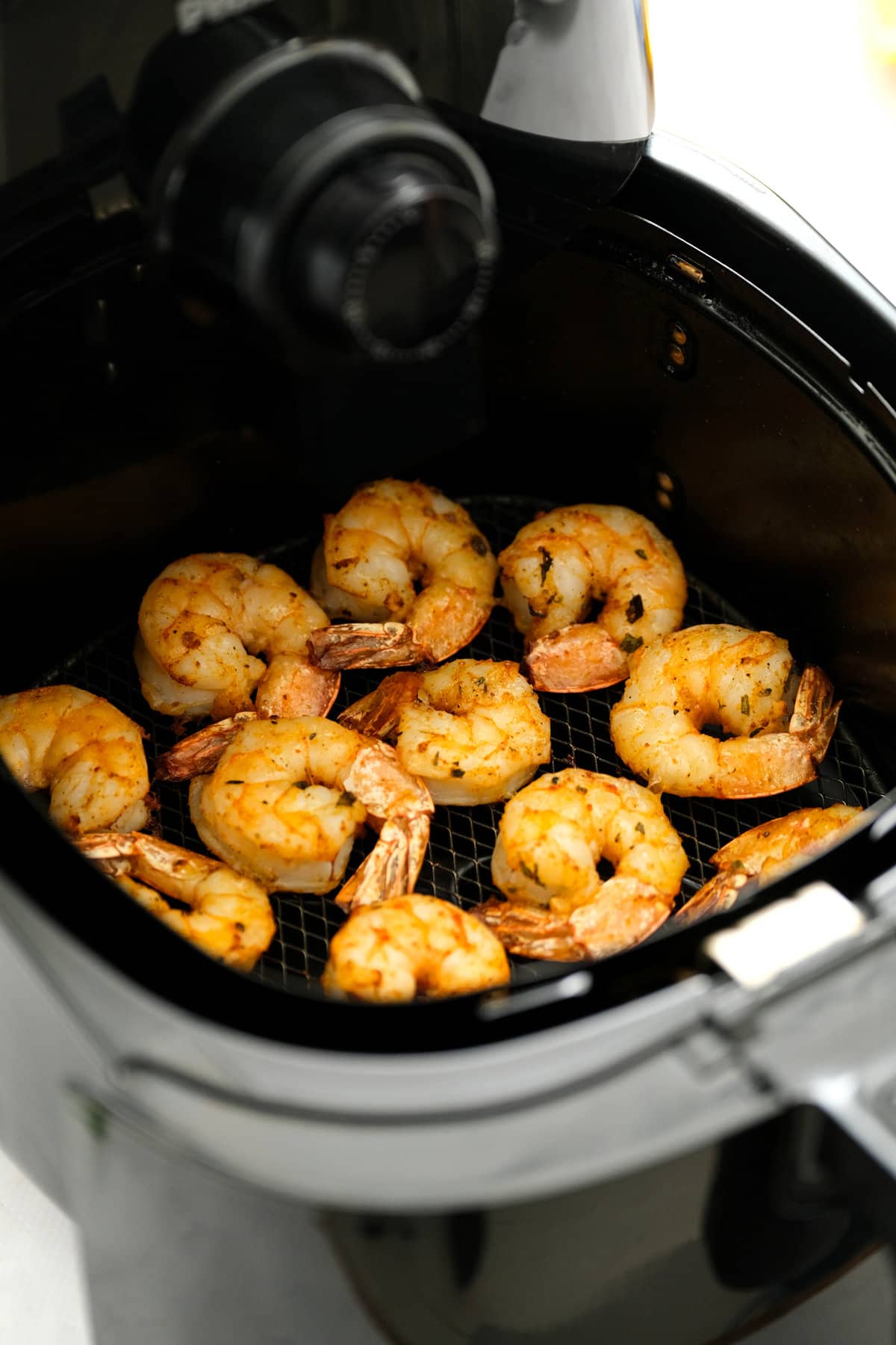 Air Fryer basket with cooked shrimp