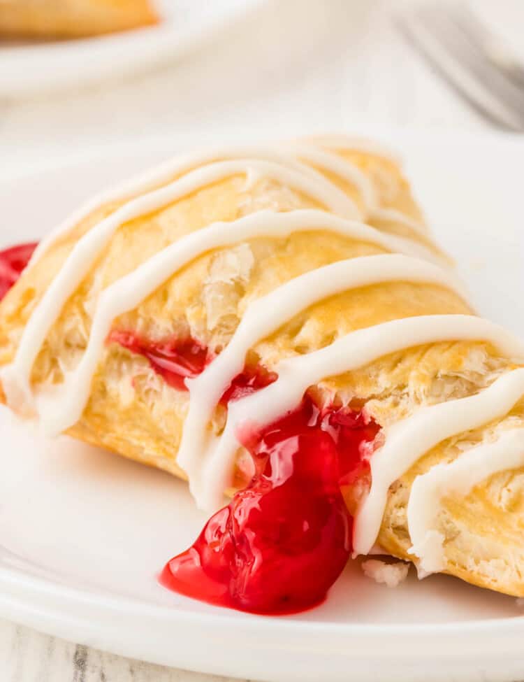 Cherry Turnovers with drizzle of frosting on white plate