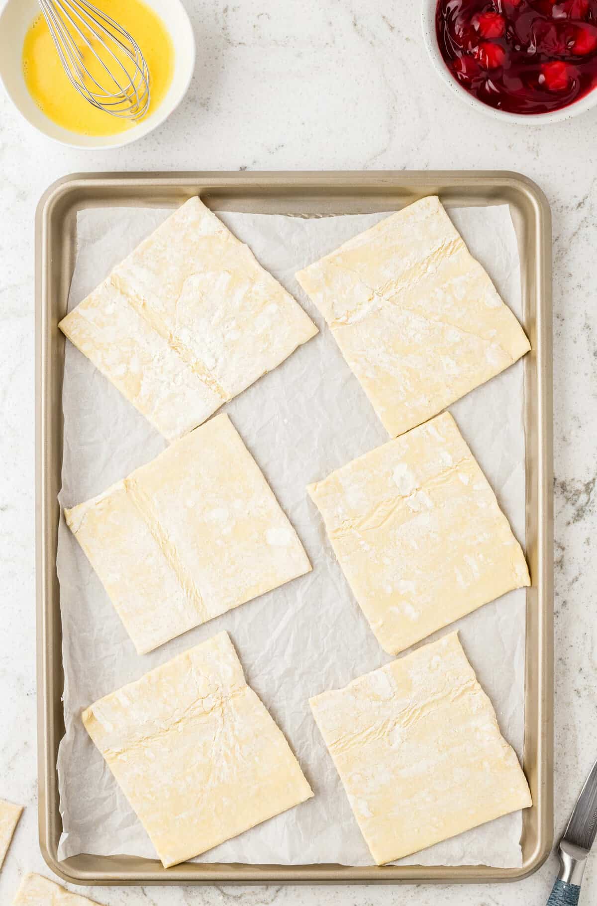 Puff Pastry Cherry Turnovers with Unbaked Pastry Square on Baking Sheet