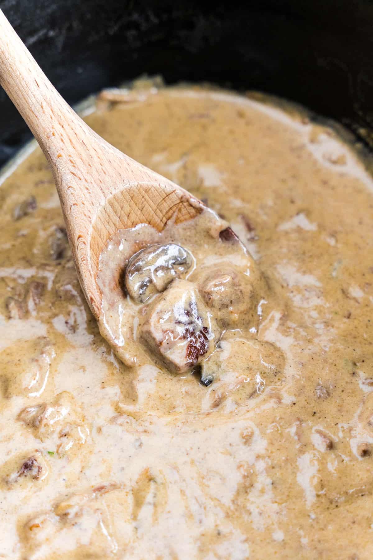 Stirring hamburger stroganoff gravy in slow cooker