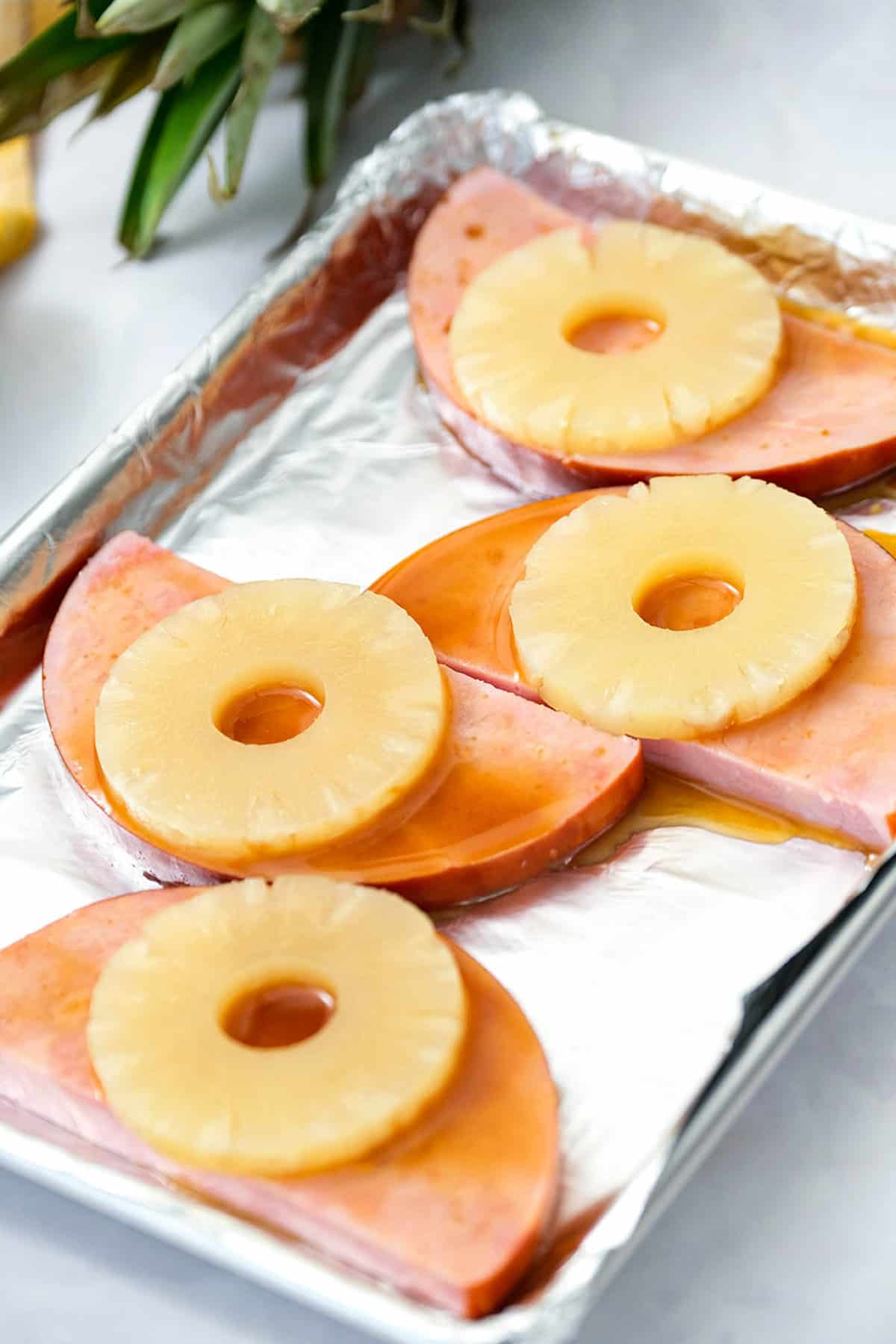 Ham Steaks with Pineapple Slices Smothered in Glaze on Baking Pan
