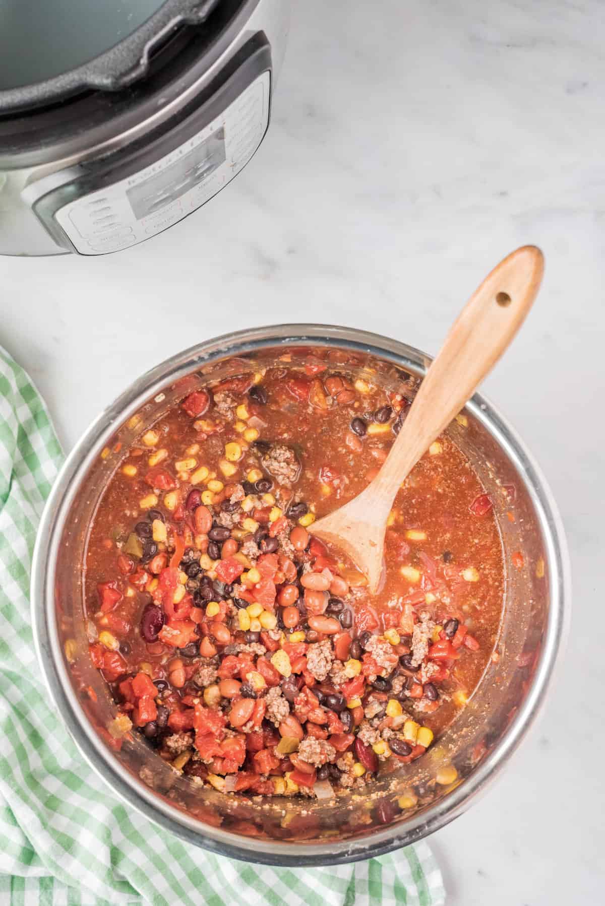 Stirring Ingredients with Wooden Spoon for Instant Pot Taco Soup Recipe