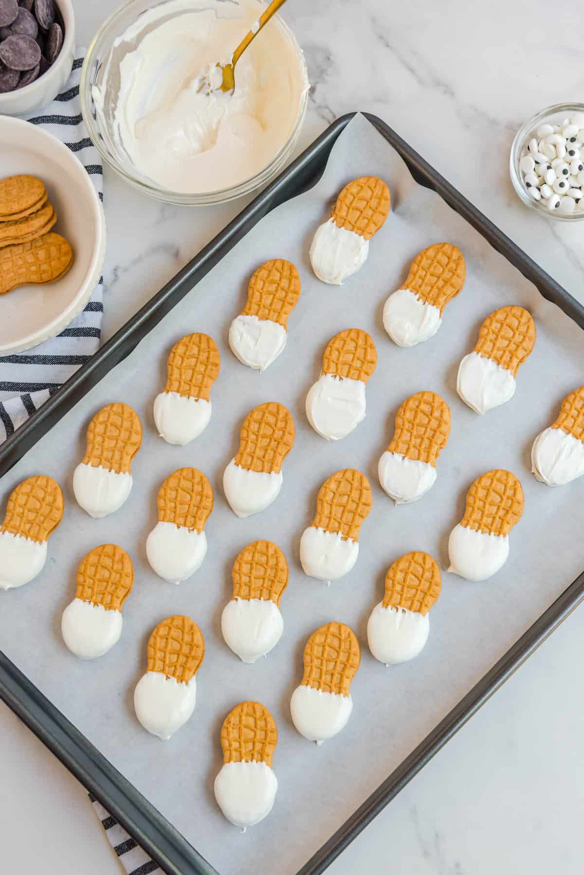 Overhead Image of Nutter Butter Cookies Dipped in White Candy Melt on Lined Cookie Sheet