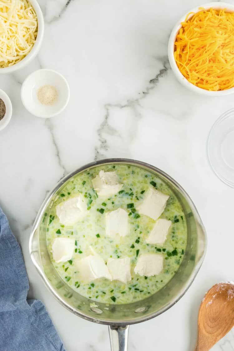 Adding Cubed Cream Cheese to Mixture in Saucepan for Homemade Queso