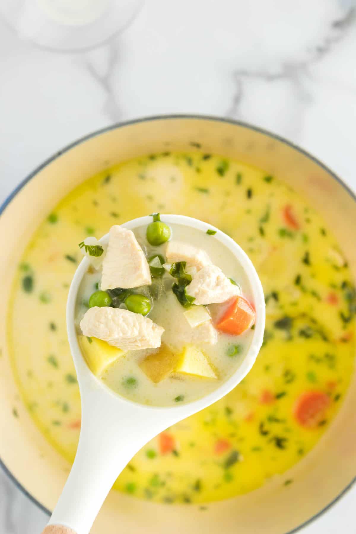 Stirring the Ingredients for Chicken Pot Pie Soup in Large Stovetop Pot