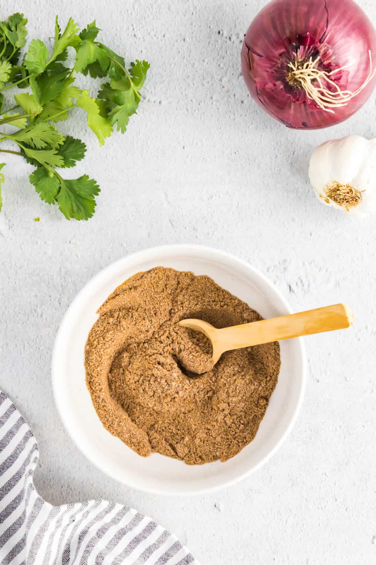 Combining Spices for Homemade Fajita Seasoning in Bowl with Wooden Spoon