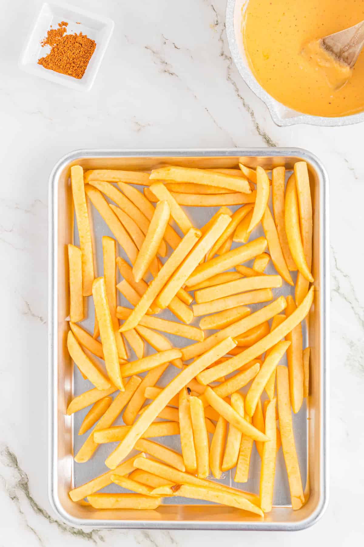 Filling Baking Sheet with Fries for Nacho Fries Recipe