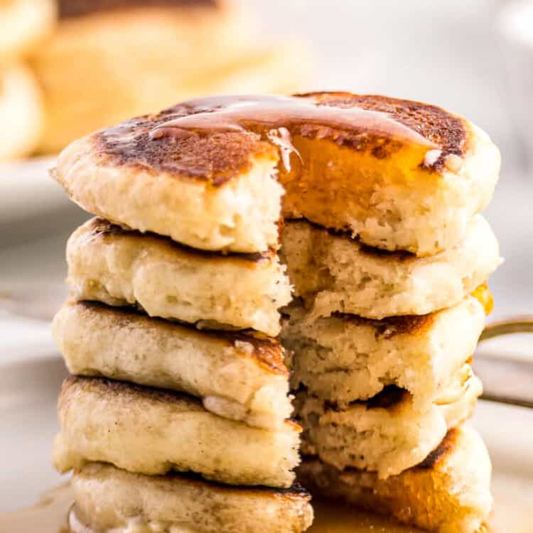 White plate with mini pancakes covered in syrup