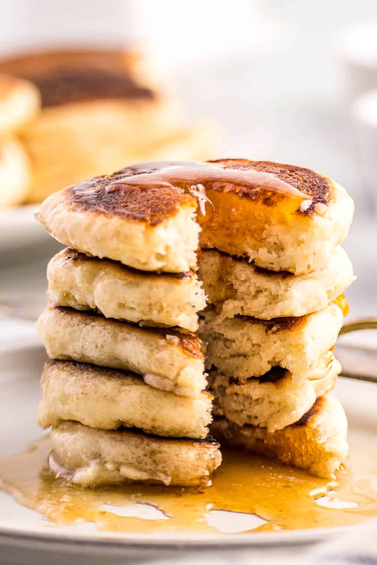 White plate with mini pancakes covered in syrup