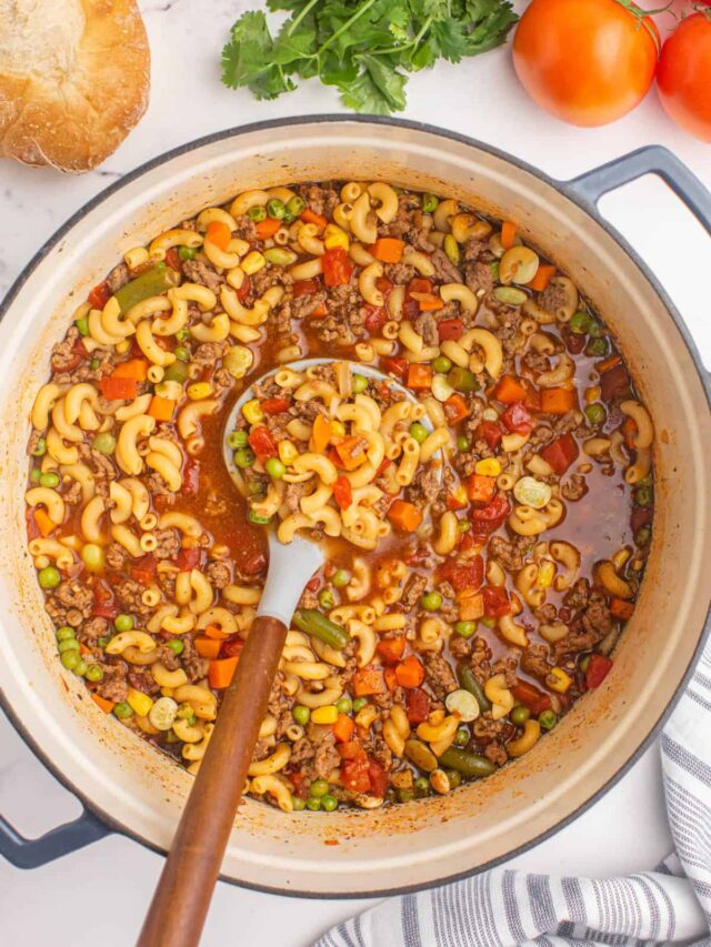 Stirring Hamburger Macaroni Soup in Dutch Oven