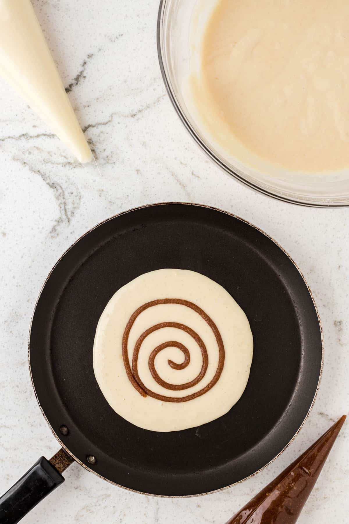 Piping Cinnamon Swirl onto Pancake for Cinnabon Pancake Recipe
