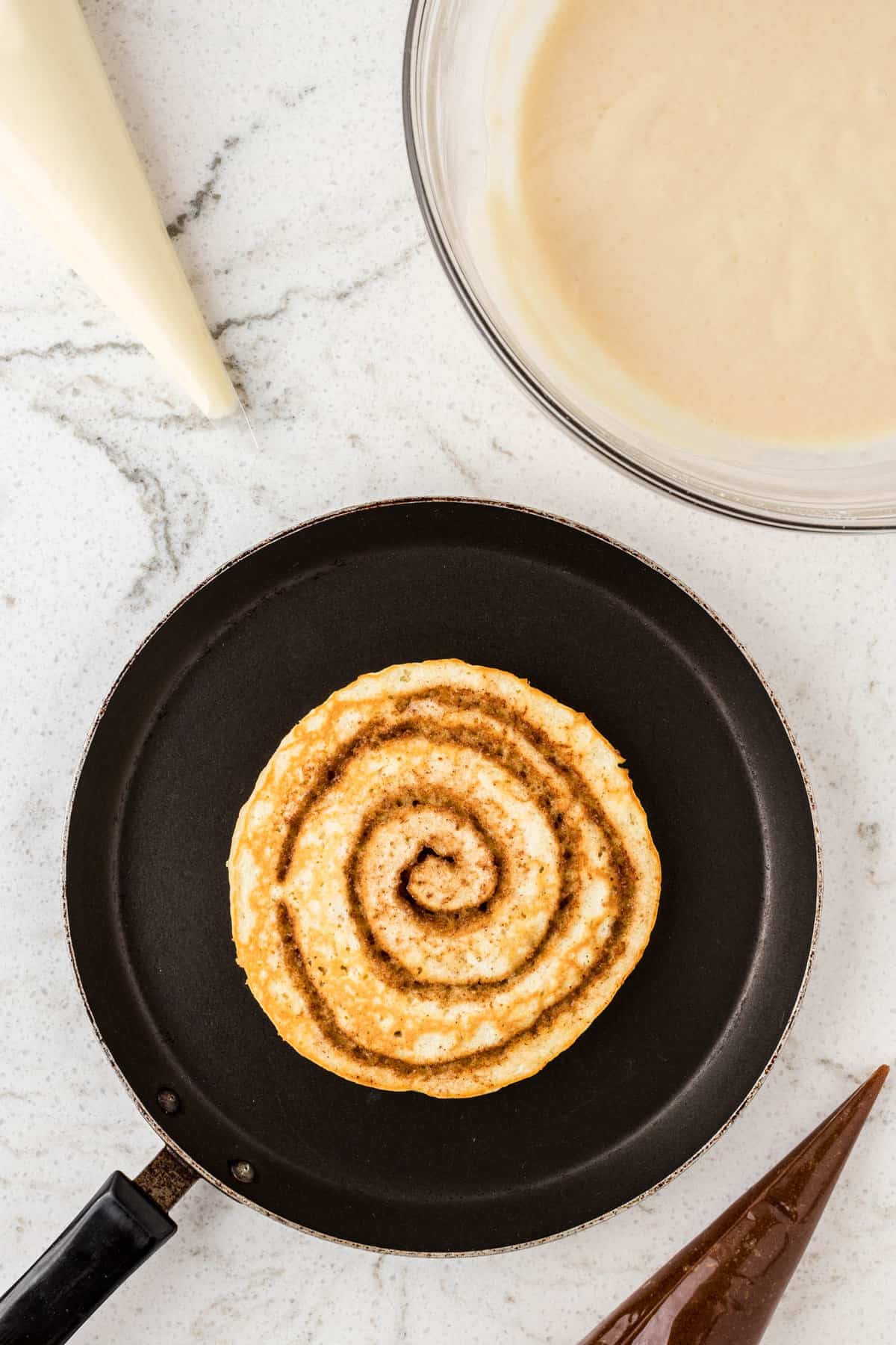 Cinnamon Swirl Pancakes on Griddle with  Golden Brown