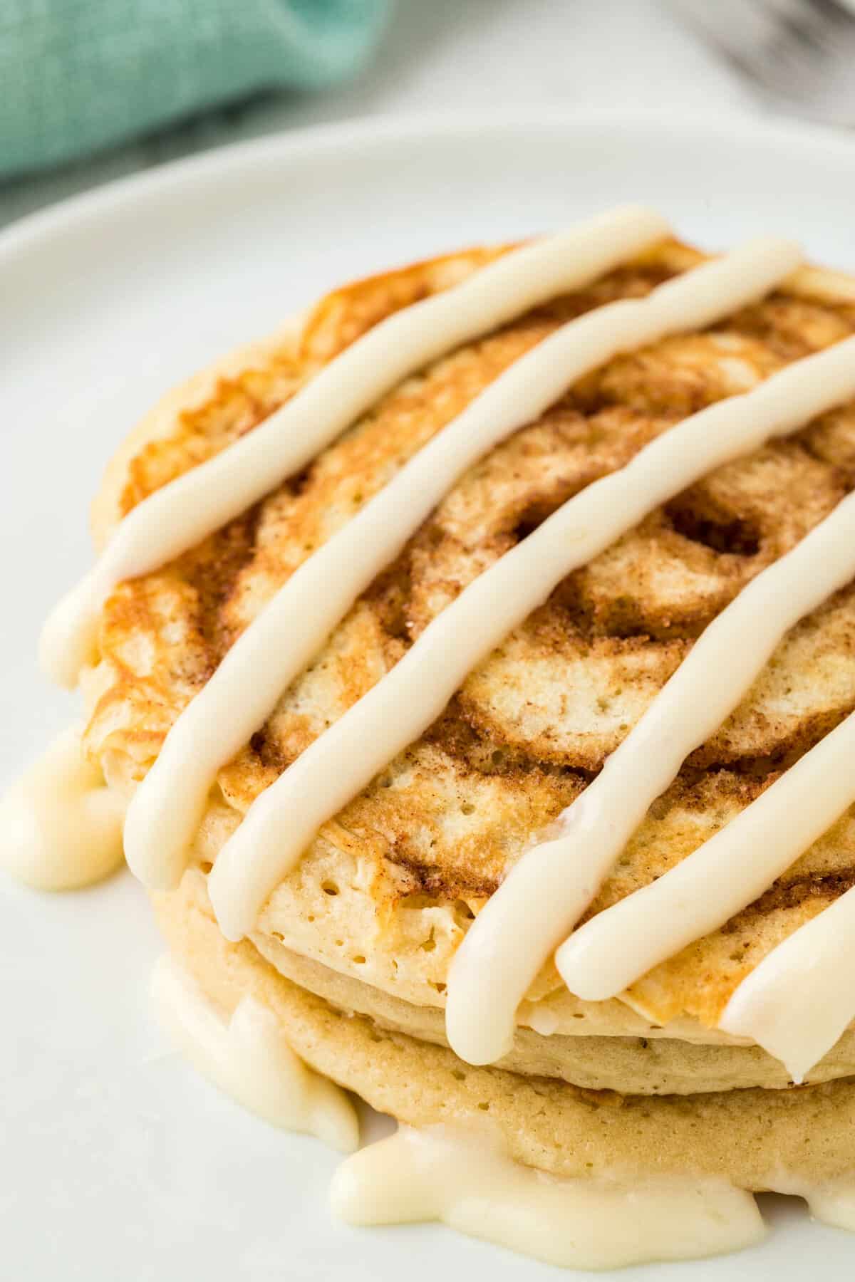 Cinnamon Swirl Pancakes on Plate Drizzled with Cream Cheese Icing