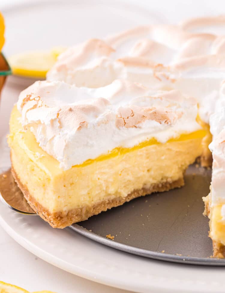 Lemon Meringue Cheesecake slice being taken from cheesecake