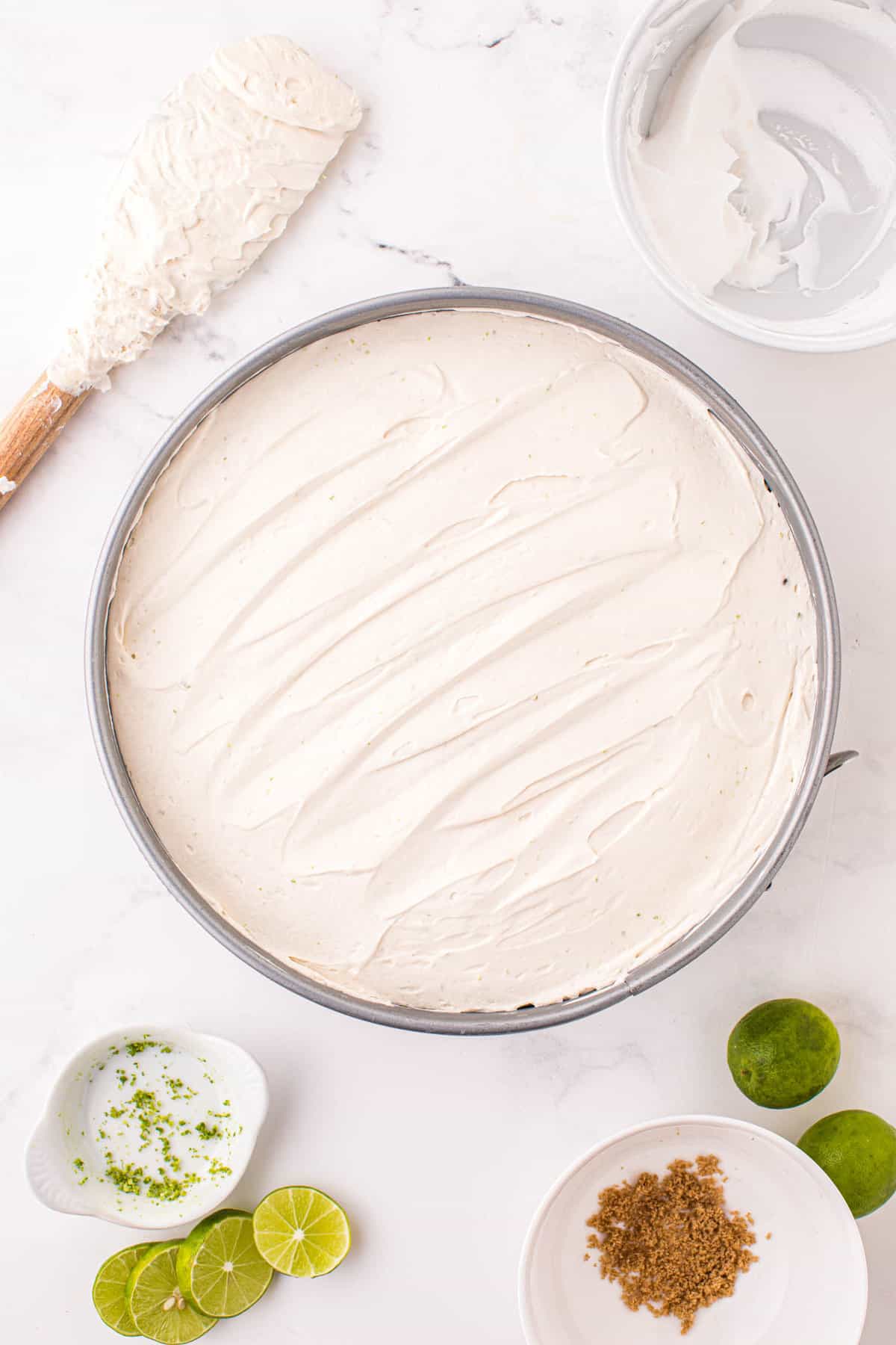 Spreading Mixture Atop Pressed Crust for No Bake Key Lime Cheesecake Recipe
