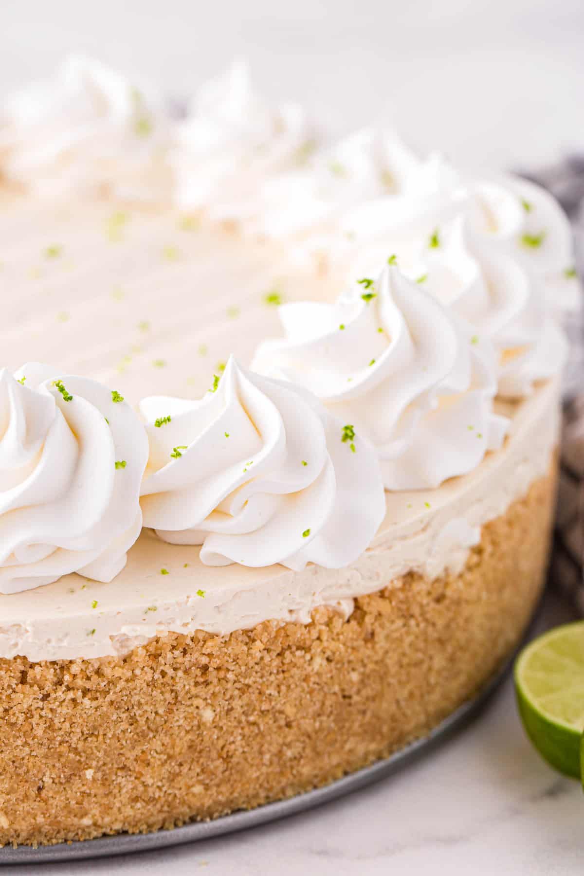 Easy Key Lime Cheesecake Recipe Topped with Whipped Cream and Key Lime