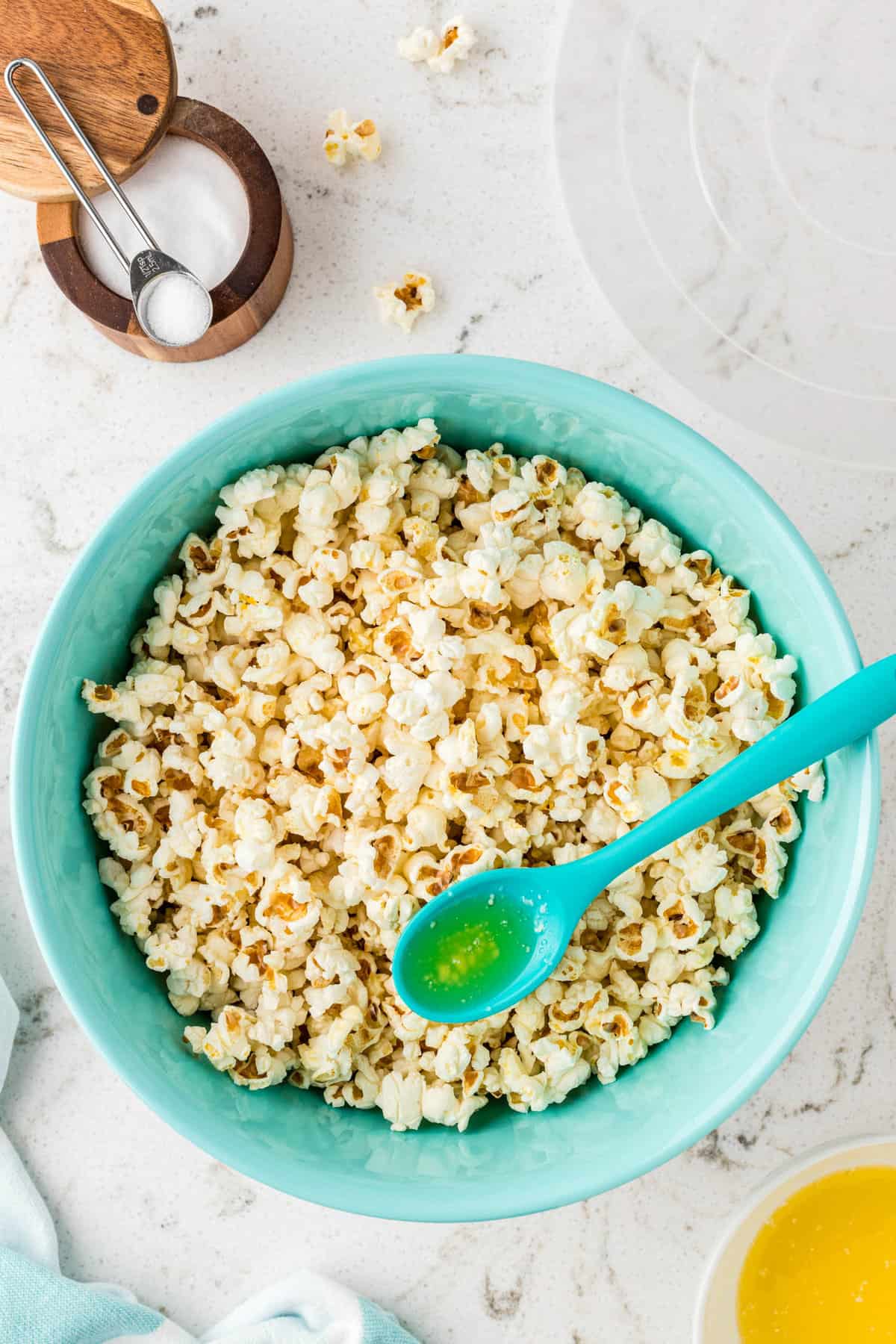 Adding Melted Butter to Popped Kernels for Homemade Stovetop Popcorn