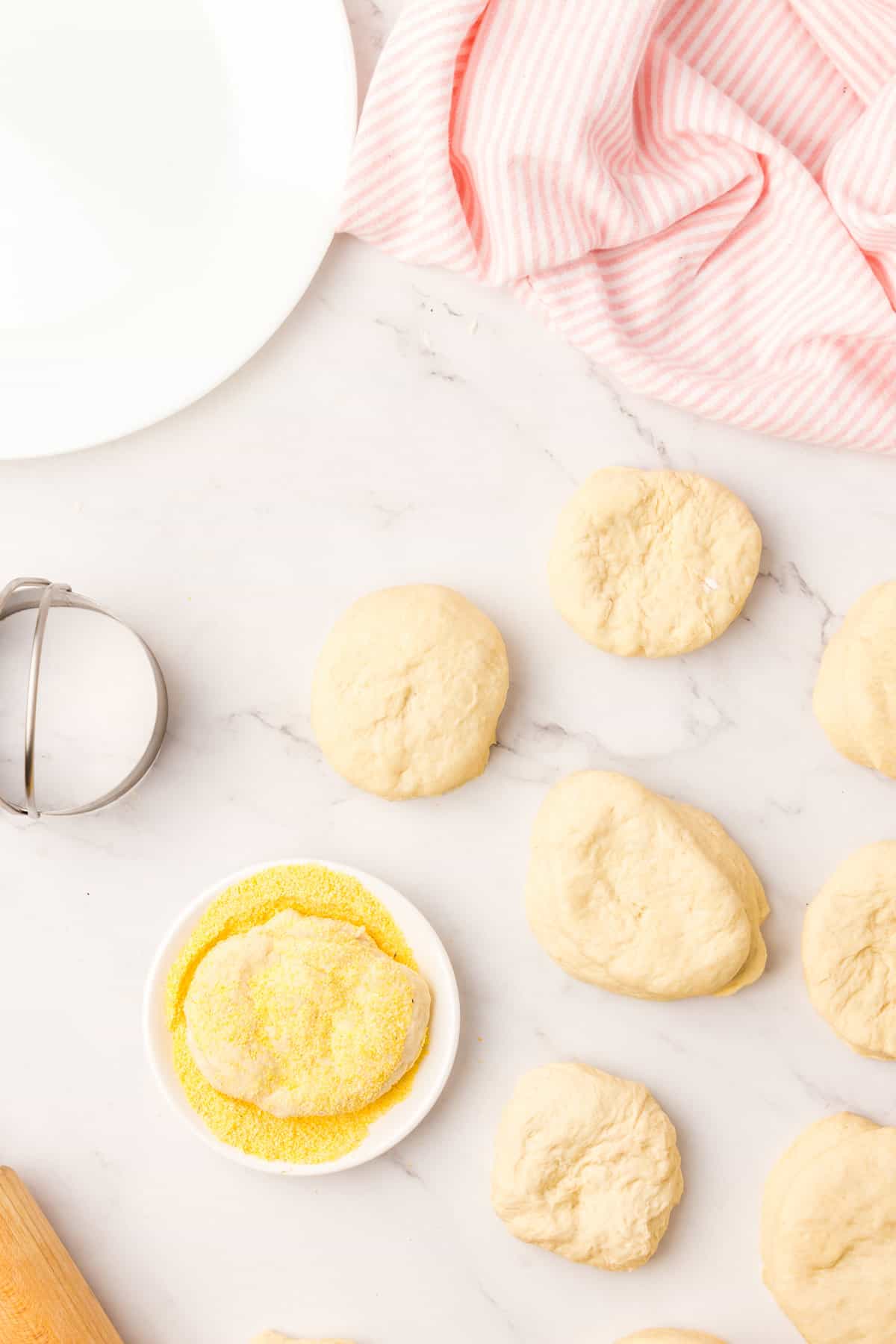 Coat Cut Dough Discs with Corn Meal for English Muffin Recipe