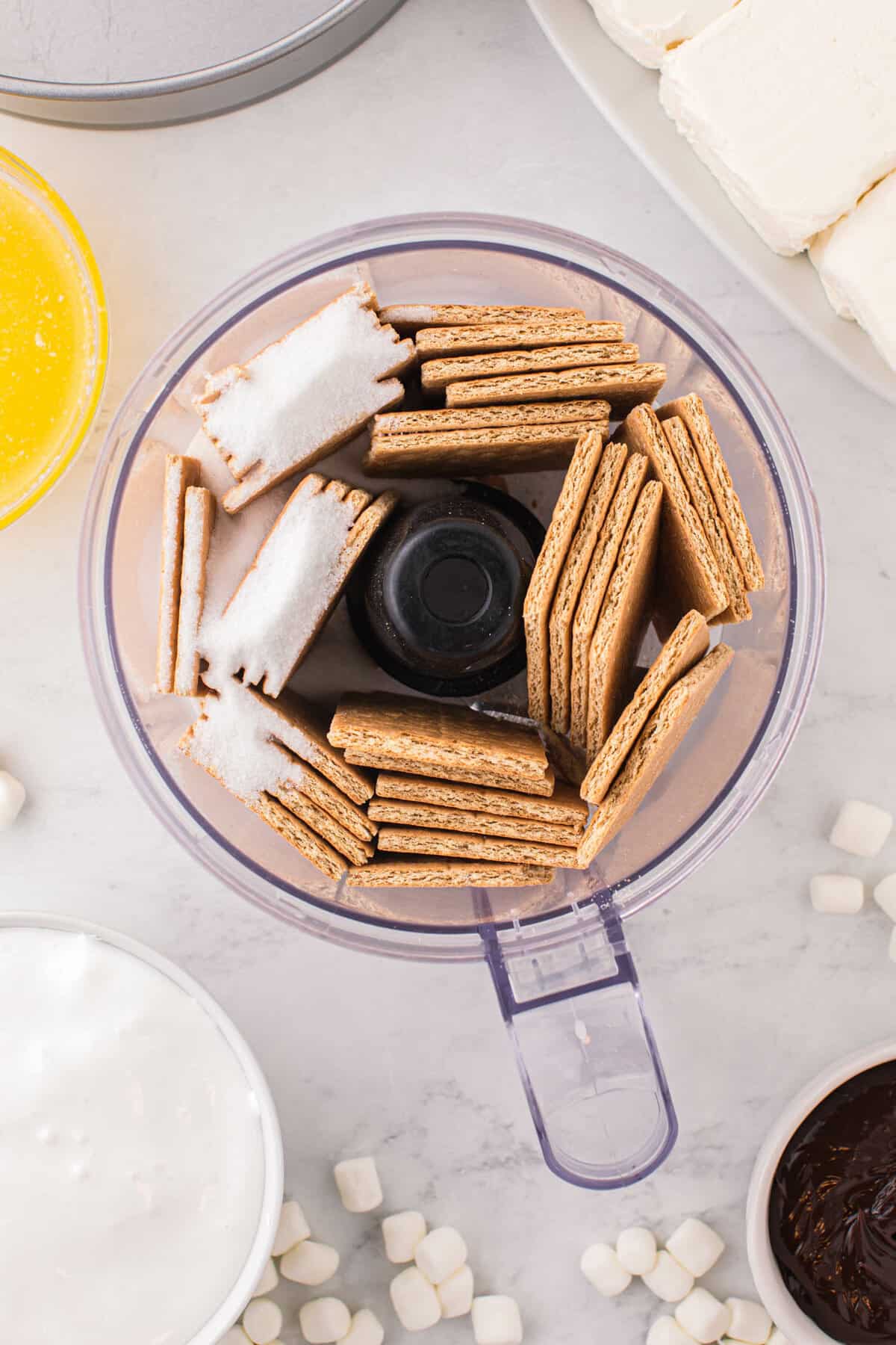 Graham Crackers and Sugar in Food Processor Ready to Blend for Crust for Smore Cheesecake Recipe