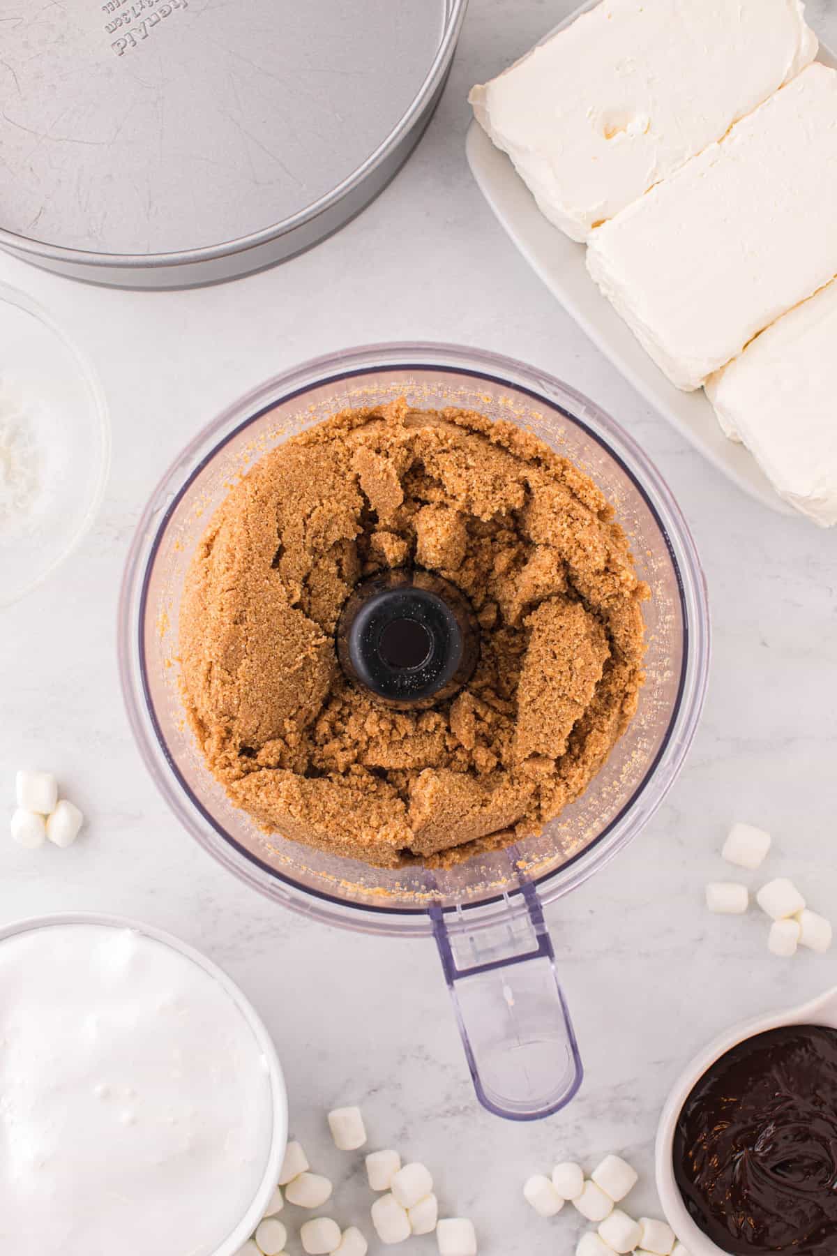 Blending Crust Ingredients for Smore Cheesecake Recipe Until it Becomes Sandy