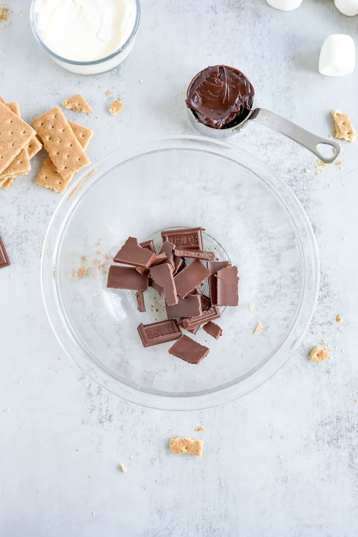 Broken Up Chocolate Pieces in Glass Bowl for S'mores Dip Recipes