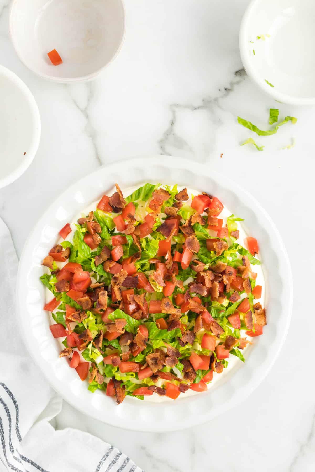 Adding crumbled bacon to BLT Dip recipe