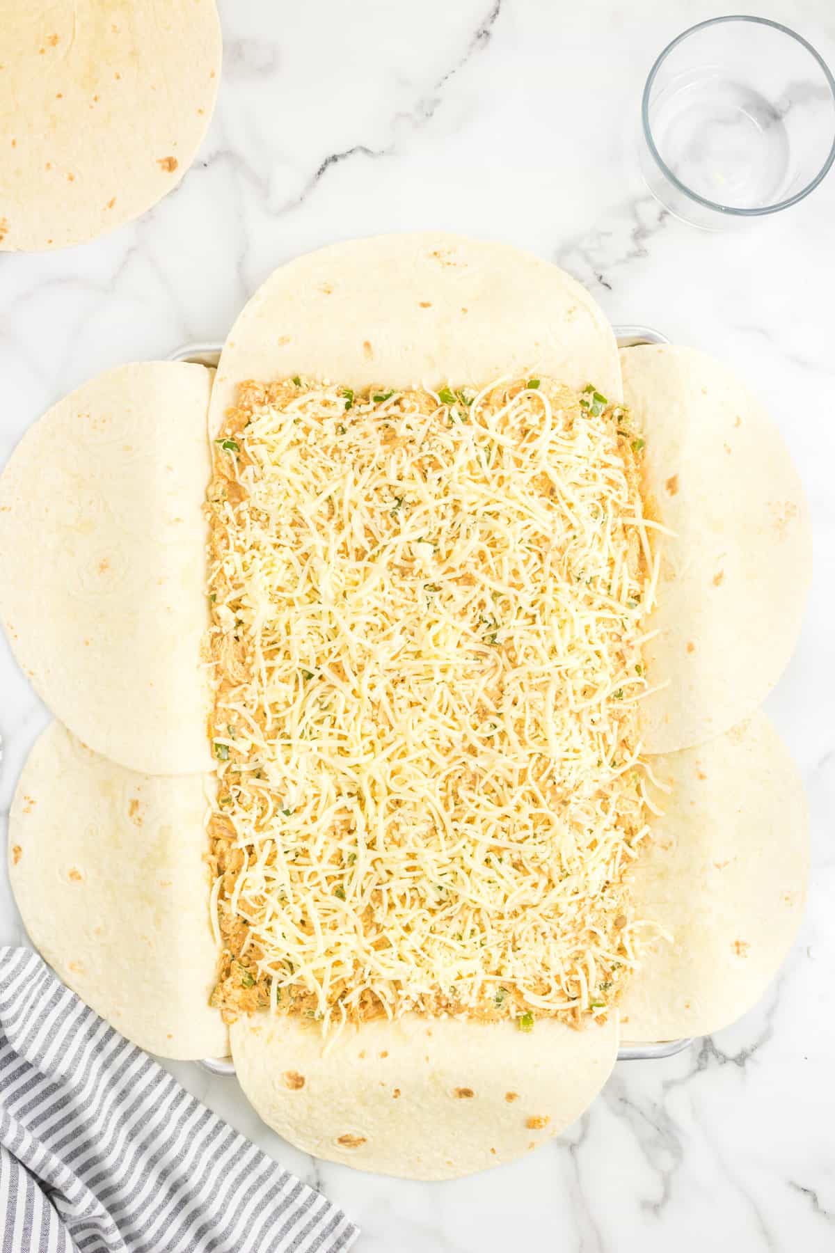 Topping Chicken Mixture with Cheese for Sheet Pan Chicken Quesadillas