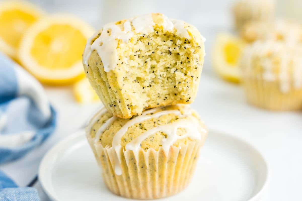 Lemon Poppy Seed Muffins Stacked on Plate Dizzled with Glaze