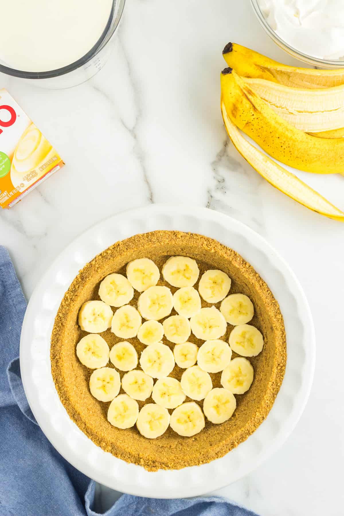 Prepared Graham Cracker Crust Lined with Sliced Bananas for No Bake Banana Cream Pie Recipe